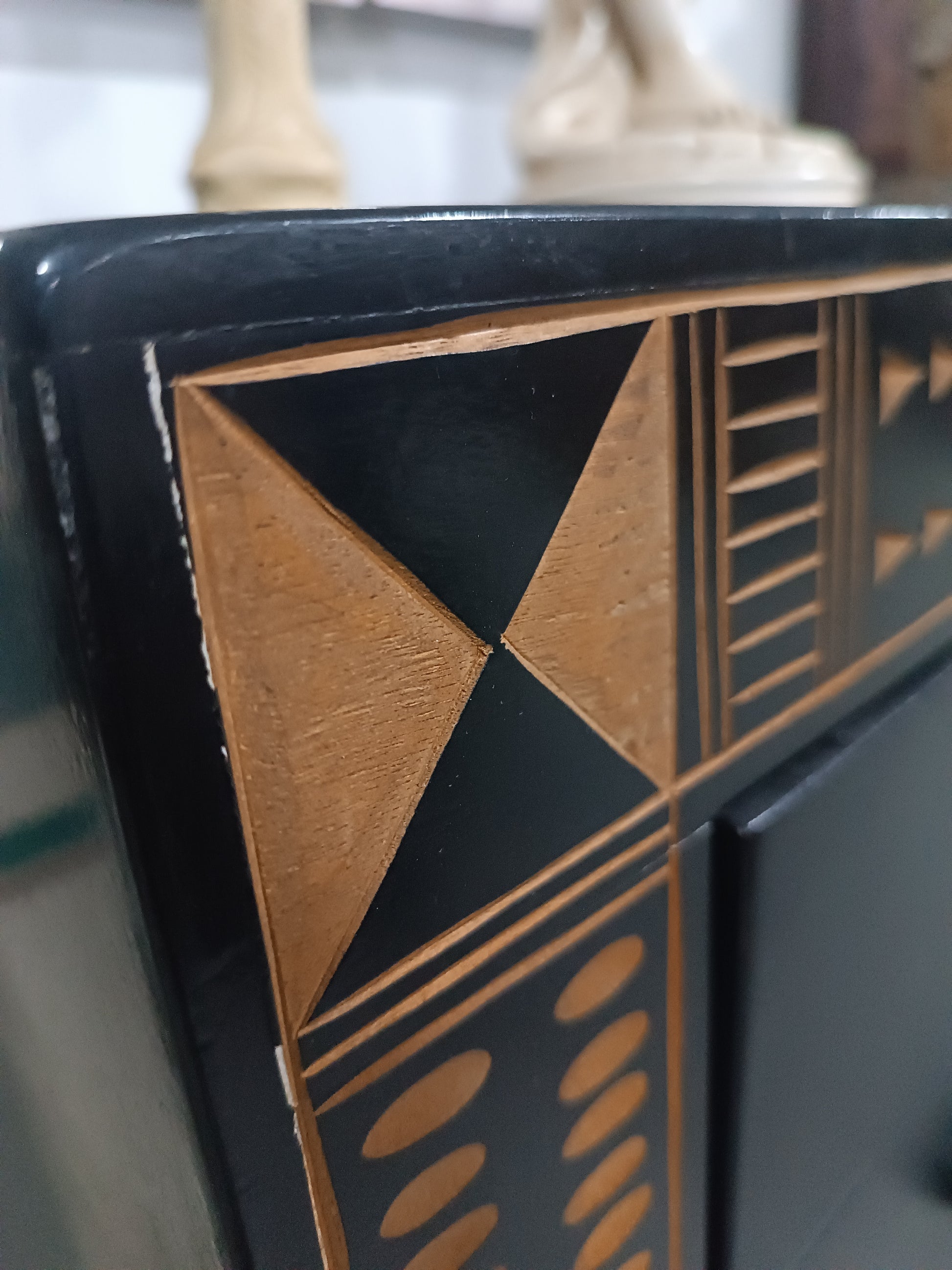 Cómoda vintage negra con detalles geométricos en madera tallada, estilo étnico-tribal.
